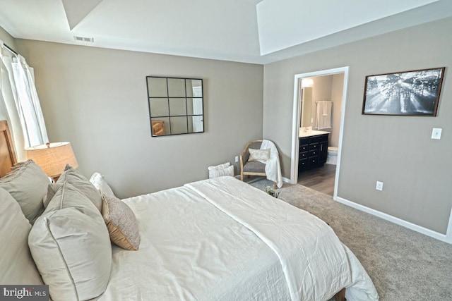 carpeted bedroom featuring ensuite bath