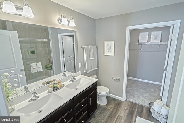 bathroom featuring hardwood / wood-style floors, vanity, toilet, and an enclosed shower