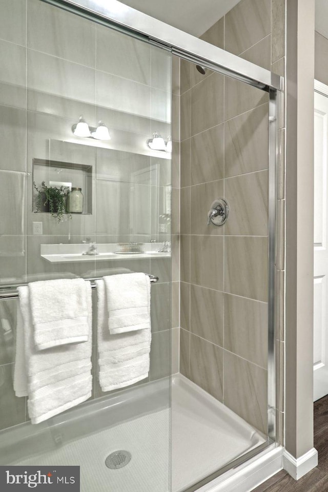 bathroom with wood-type flooring and walk in shower