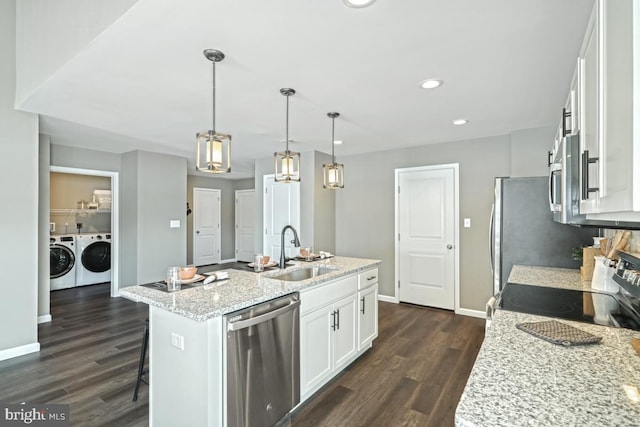 kitchen with a kitchen island with sink, white cabinets, sink, appliances with stainless steel finishes, and light stone counters