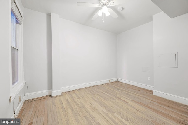 spare room featuring hardwood / wood-style floors, a ceiling fan, and baseboards