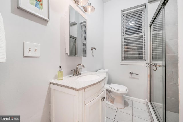 full bath featuring toilet, a tile shower, vanity, baseboards, and tile patterned floors