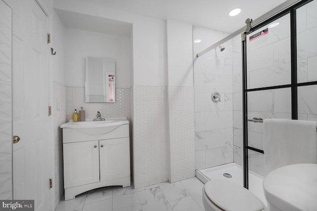 bathroom featuring marble finish floor, tile walls, toilet, a stall shower, and vanity