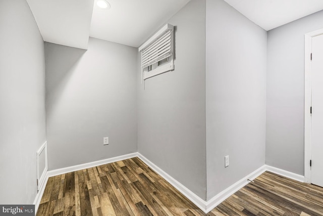 spare room with wood finished floors, visible vents, and baseboards