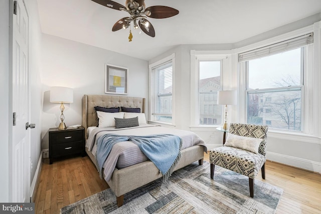 bedroom featuring ceiling fan, baseboards, and hardwood / wood-style flooring