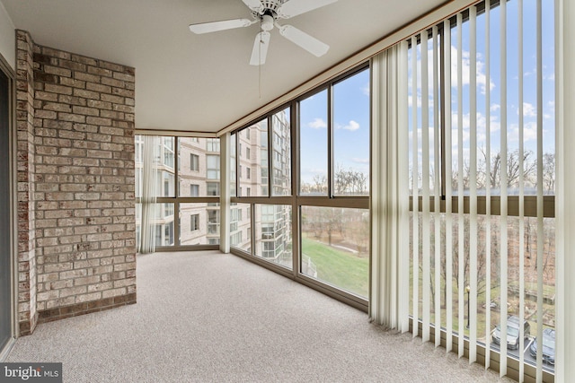 unfurnished sunroom featuring a ceiling fan