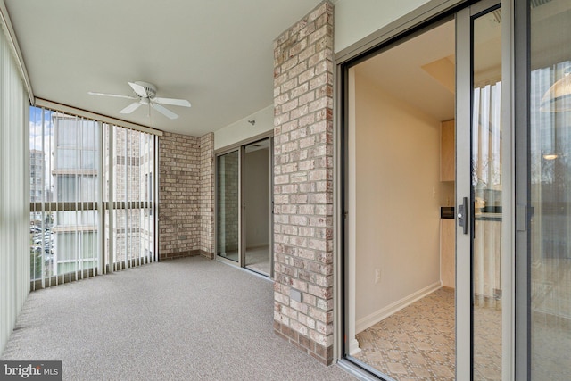 unfurnished sunroom featuring a ceiling fan