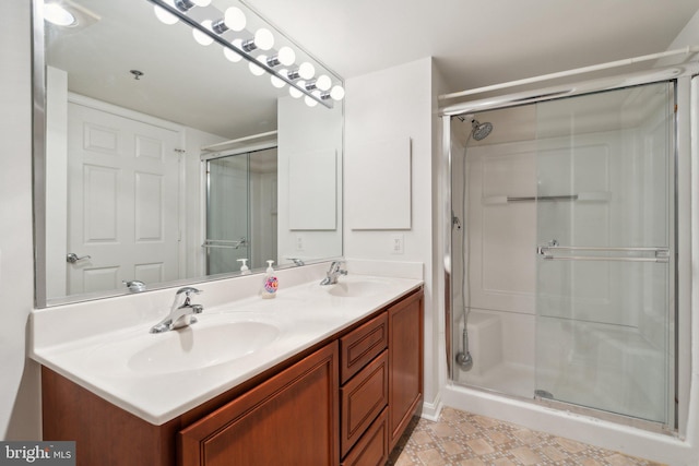 bathroom with double vanity, a stall shower, and a sink