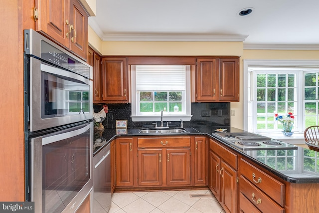 kitchen featuring backsplash, crown molding, sink, and stainless steel appliances