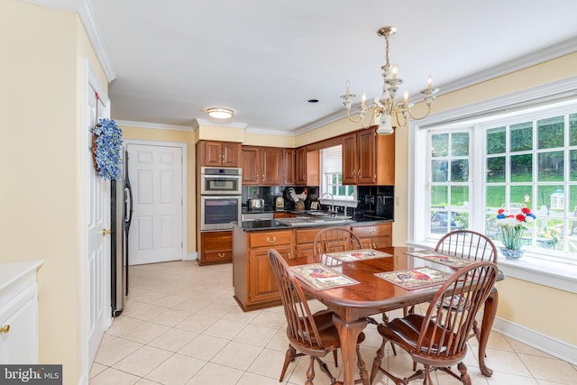 kitchen with decorative backsplash, ornamental molding, a notable chandelier, light tile patterned flooring, and stainless steel appliances