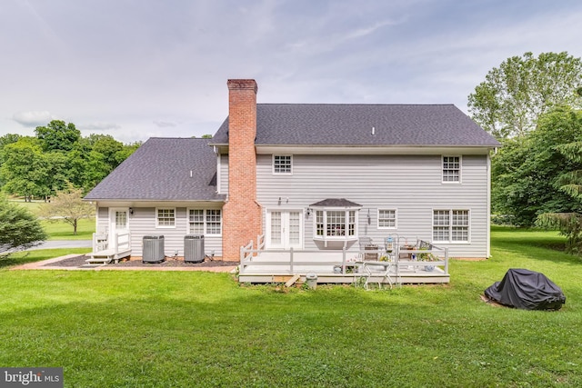 back of house with a deck, a yard, and central AC