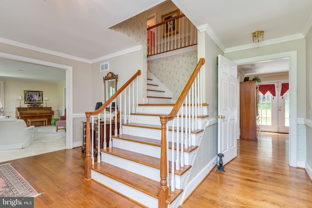 stairs featuring wood-type flooring, french doors, and ornamental molding