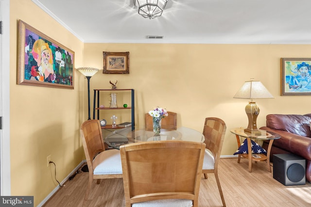 dining space featuring hardwood / wood-style floors and crown molding