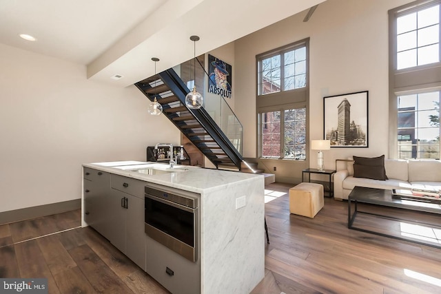 kitchen featuring dark hardwood / wood-style floors, sink, hanging light fixtures, and plenty of natural light