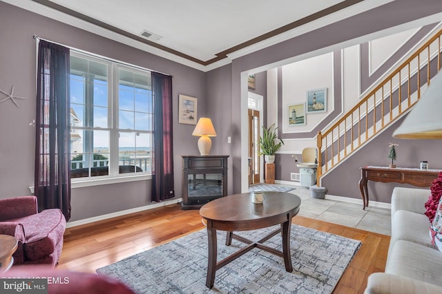 living room with light hardwood / wood-style flooring and crown molding