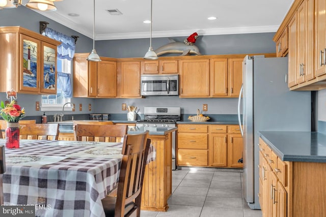 kitchen with pendant lighting, light tile patterned flooring, crown molding, and appliances with stainless steel finishes