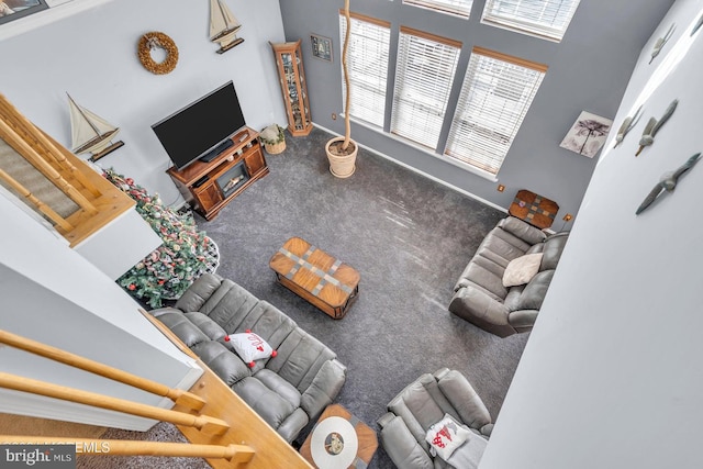 unfurnished living room with carpet floors and a towering ceiling