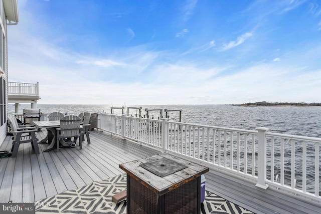 deck featuring a water view and an outdoor fire pit