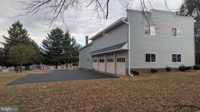 view of home's exterior with a lawn and a garage