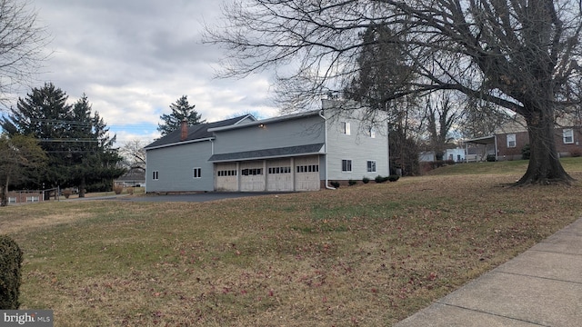 view of side of home featuring a yard and a garage