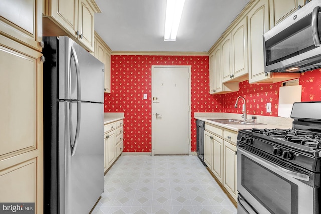 kitchen with sink, stainless steel appliances, and cream cabinets