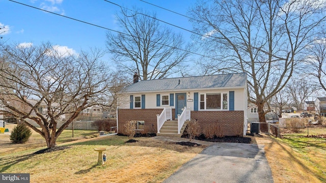 bungalow featuring a front lawn and central air condition unit