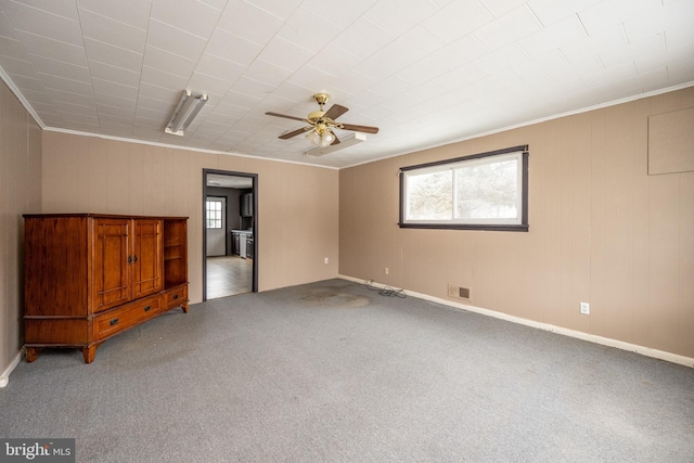 carpeted spare room featuring ceiling fan and ornamental molding