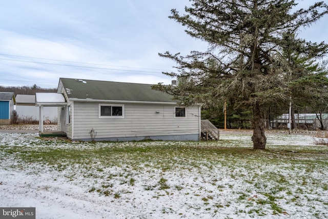 view of snow covered back of property