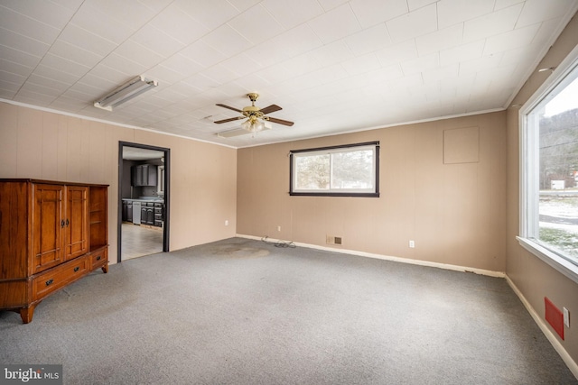 carpeted spare room featuring crown molding and ceiling fan