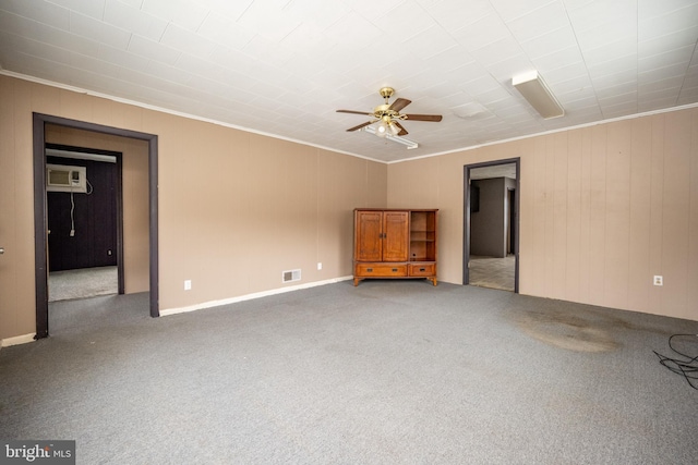 empty room with a wall mounted air conditioner, carpet floors, and ornamental molding