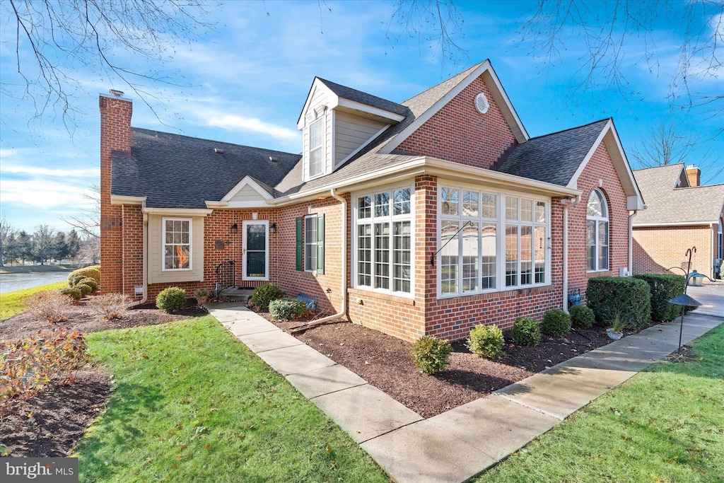 view of front of property featuring a front lawn and a sunroom