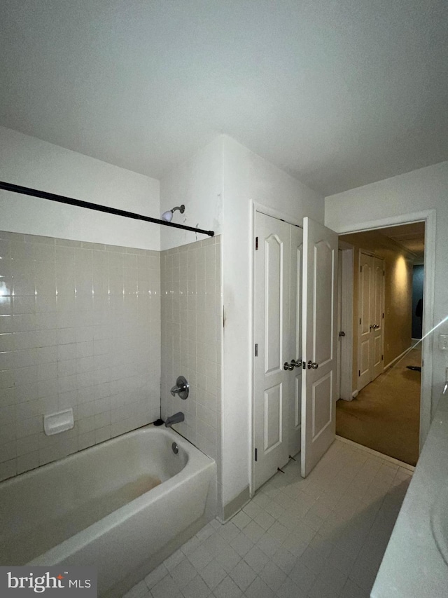 bathroom featuring tile patterned flooring and tiled shower / bath