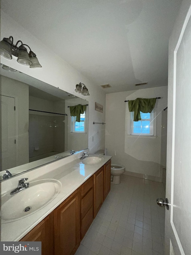 bathroom featuring tile patterned flooring, vanity, toilet, and walk in shower