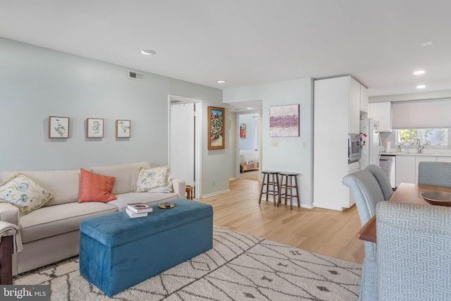 living room with light wood-type flooring and sink