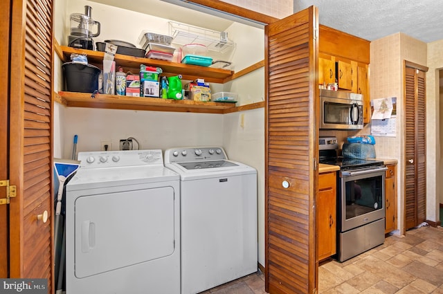 washroom featuring washing machine and dryer and a textured ceiling