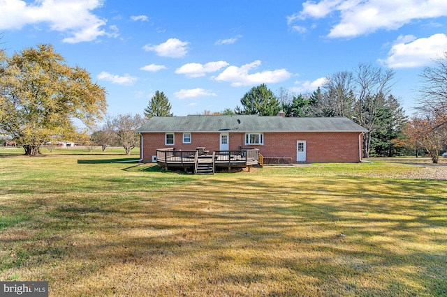 back of property with a yard and a wooden deck