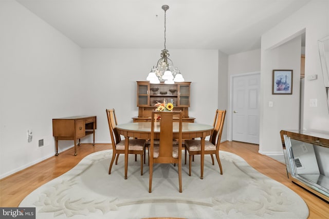 dining area featuring a notable chandelier and hardwood / wood-style flooring