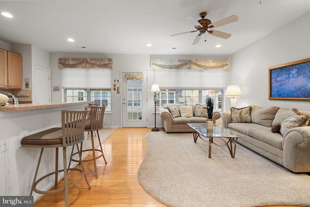 living room featuring ceiling fan and light wood-type flooring