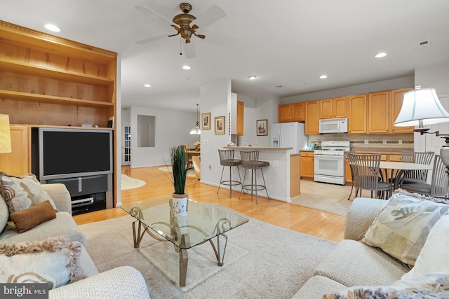 living room with light wood-type flooring and ceiling fan