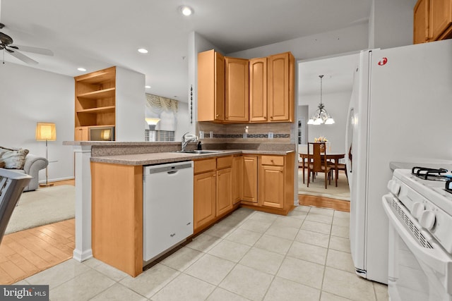 kitchen featuring sink, light hardwood / wood-style flooring, pendant lighting, white appliances, and ceiling fan with notable chandelier