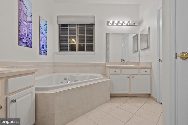 bathroom featuring tile patterned flooring, vanity, and tiled tub