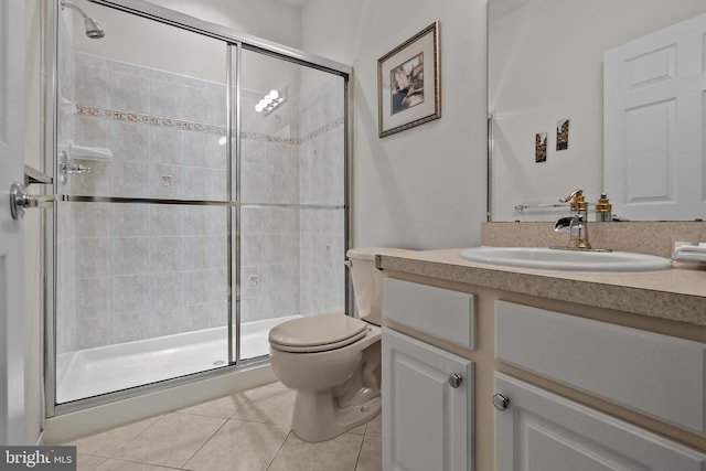 bathroom with tile patterned flooring, vanity, toilet, and a shower with shower door