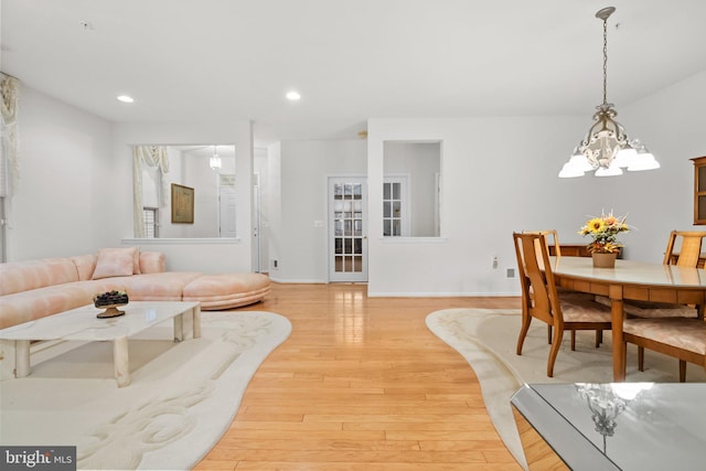 living room featuring a notable chandelier and light wood-type flooring