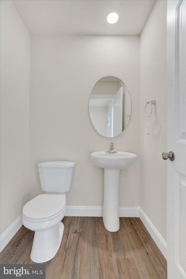 bathroom featuring hardwood / wood-style floors and toilet