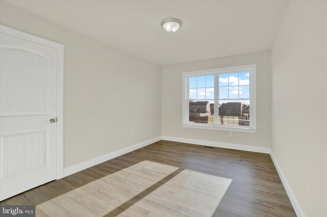 spare room with dark hardwood / wood-style flooring