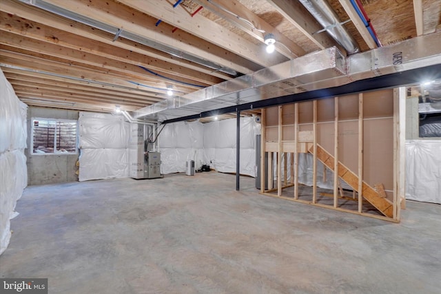 basement featuring water heater and heating unit