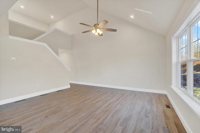 empty room featuring ceiling fan, hardwood / wood-style floors, and high vaulted ceiling