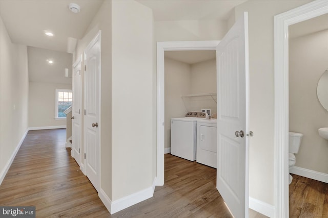 hallway featuring washer and dryer and light hardwood / wood-style flooring