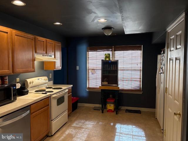 kitchen with white range with electric cooktop, dishwasher, and light tile patterned floors