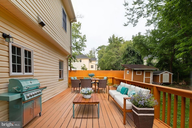 deck featuring a shed, grilling area, and an outdoor hangout area